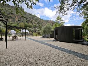 a building with a tent and a picnic table at River Glamping Kalopanayiotis in Kalopanayiotis