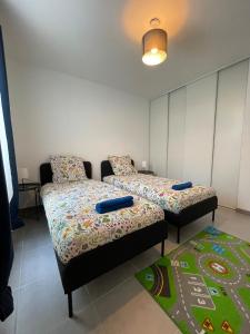 2 Betten und ein Sofa in einem Zimmer in der Unterkunft Casa Candela in Magny-le-Hongre