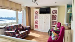 a living room with two chairs and a table at 6-401, Extravagante Strandwohnung, Art Nouveau meets französischen Landhausstil! 1Zimmer in Westerland (Sylt)