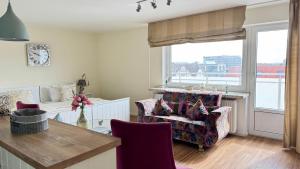 a living room with a chair and a window at 6-401, Extravagante Strandwohnung, Art Nouveau meets französischen Landhausstil! 1Zimmer in Westerland (Sylt)