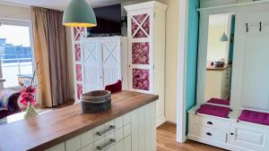 a kitchen with white cabinets and a large window at 6-401, Extravagante Strandwohnung, Art Nouveau meets französischen Landhausstil! 1Zimmer in Westerland (Sylt)