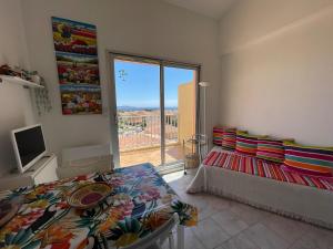 a living room with a bed and a large window at Duplex Cozy - Piscine - Vue Mer in Carqueiranne
