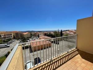 a balcony with a view of a city at Duplex Cozy - Piscine - Vue Mer in Carqueiranne