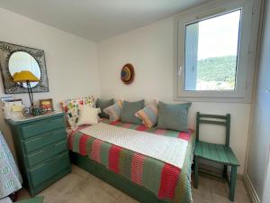 a bedroom with a bed with a dresser and a window at Duplex Cozy - Piscine - Vue Mer in Carqueiranne +2 photos