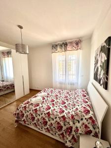 a bedroom with a bed with a floral bedspread at Verdeacqua my villa in the pinewood in Spotorno +69 photos
