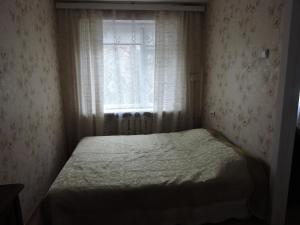 een kleine slaapkamer met een bed en een raam bij Karja 5 Apartment in Narva-Jõesuu