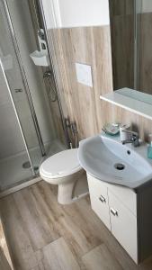 Un baño con inodoro, lavabo y ducha. en suite attico Acqua marina, en Porto Cesareo