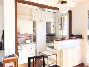 une cuisine avec des placards blancs et une chaise noire dans l'établissement Casa Lisa a Casale Marittimo by Zoom In Earth, à Casale Marittimo