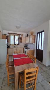 a kitchen with a wooden table with chairs and a kitchen with a refrigerator at Tsigaridas Mountain Home in Neokhórion +77 photos