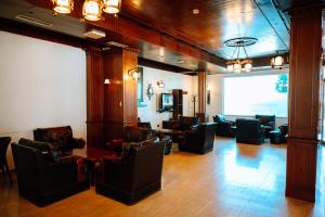 a lobby with chairs and a table and a large window at Hotel Delta in Durrës