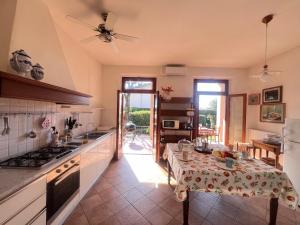 a kitchen with a table in the middle of it at Villa Biba tra Lucca e Pisa in Avane