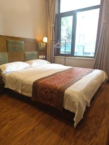 Postel nebo postele na pokoji v ubytování Beijing Huiqing Garden Bussiness Hotel