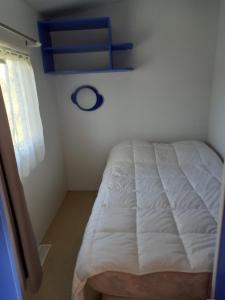 a white bed in a room with a window at les braves in Saint-Laurent-sur-Mer