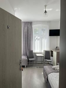 a hotel room with a bed and a table and chairs at Willa WIBOR ulica Tęsknoty 5 Dziwnów in Dziwnów
