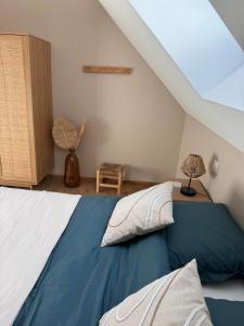 a bedroom with a bed with a blue blanket at Gîte de la forêt de Sperleka in Éperlecques