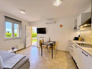 een keuken en een woonkamer met een tafel en een bed bij Apartments Pinta de Sol in Čižići