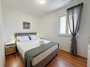 een slaapkamer met een groot bed en een raam bij Apartments Pinta de Sol in Čižići