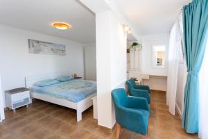 een slaapkamer met een bed en twee blauwe stoelen bij Apartman Tekoma Herceg Novi in Herceg-Novi +33 foto's