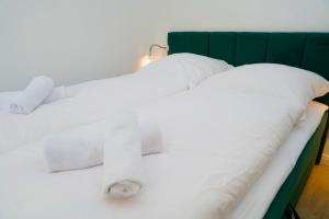 two beds with white sheets and a green headboard at unique - studio - Balkon - Küche -Waschmaschine in Bremen