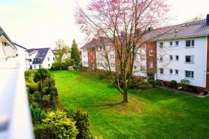 a green yard with a tree and buildings at unique - studio - Balkon - Küche -Waschmaschine in Bremen