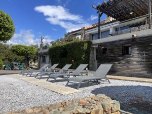 a row of lounge chairs in front of a building at Casadelys in Cala Rossa