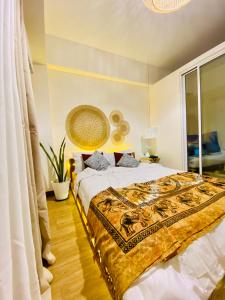 a bedroom with a large bed with a blanket on it at Den and Then - Sky Lounge Haven in Manila
