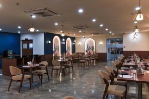 a restaurant with tables and chairs and a bar at Ginger Vadodara RCR in Vadodara