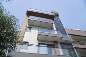 un alto edificio bianco con finestre in vetro di Staybia Hotel and Service Apartments, Sector-27, Noida a Noida