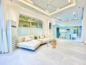 Una sala de estar con un sofá blanco y una mesa. en Villa Đà Nẵng LN View, en Da Nang