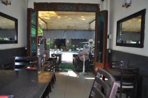 a dining room with tables and chairs and a door at Velkommen Guesthouse Phnom Penh in Phnom Penh