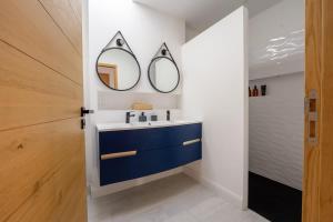Un baño con un lavabo y dos espejos en la pared. en La Villa des Vagues, en Châtelaillon-Plage