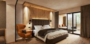 a bedroom with a large bed and a chair at Der Rindererhof in Tux