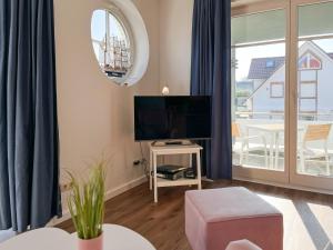 sala de estar con ventana grande y TV en Dünenblick Wohnung 24, en Boltenhagen