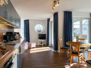 Una cocina y una sala de estar con mesa y sillas. en Dünenblick Wohnung 24, en Boltenhagen