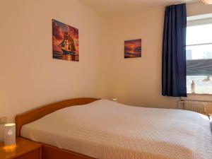 un dormitorio con una cama y una ventana en Dünenblick Wohnung 24, en Boltenhagen