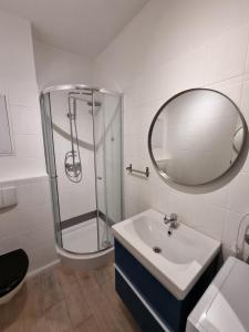a bathroom with a shower and a sink and a mirror at Ferienwohnung mit Meerblick & 2 Balkonen in Sassnitz +16 photos