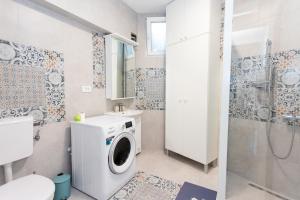 een badkamer met een wasmachine en een douche bij Apartman Tekoma Herceg Novi in Herceg-Novi
