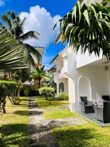 un patio de una casa con palmeras en B&B Pereybere Mauritius, en Pereybere