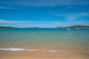 a beach with some boats in the water at La Sciumara with beach access - Happy Rentals in Cannigione