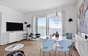 a living room with a table and chairs and a television at Stunning Home In Allinge With Wifi in Allinge