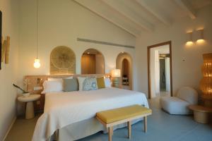a bedroom with a large white bed and a chair at Salino Port Soller-Adults Only in Port de Soller