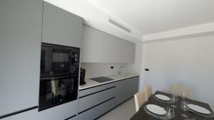 Una cocina blanca con una mesa y un microondas. en El Callejón, en Jaraguas 8 fotos más