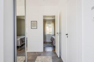 un corridoio con pareti bianche e specchio di Stenhuset a Linköping