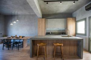 a kitchen with a large island with a table and chairs at Elounda Mimal Luxury Suite in Elounda
