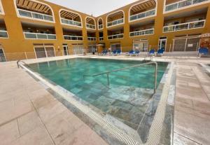 a swimming pool in the courtyard of a building at Residencial Cotillo Playa in Cotillo