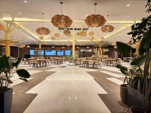a restaurant with tables and chairs and potted plants at Hotel Prince Garden Daman in Daman