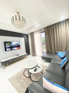 a living room with a couch and a tv at Executive One bed - East legon in Accra