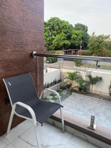 a chair sitting on a balcony next to a swimming pool at Executive One bed - East legon in Accra