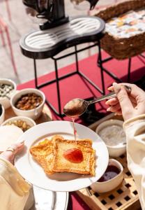 Eine Person hält einen Teller mit einer Scheibe Toast. in der Unterkunft LEV Lifestyle Hotel - Maestro in Lwiw + 60 Fotos