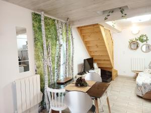 Una pequeña sala de estar con una mesa y sillas. en L'Écrin des Bois - Au bord de l Aude, en Espéraza